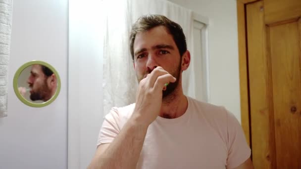 close-up fornt uitzicht op een jonge man poetsen tanden kijken naar camera, knappe man genieten ochtend orale hygiënische routine, schoonheid mannelijke zorg - Video