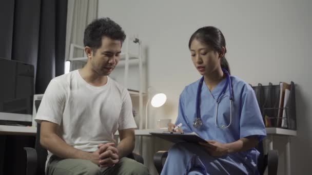Férfi beteg látogat ázsiai női orvos megvitatása egészség és gyógyszer a klinikán. - Felvétel, videó