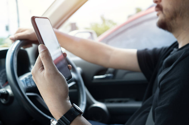 Молодий чоловік читає повідомлення, що тримають мобільний телефон під час руху. Небезпечна поведінка, нещасний ризик. Небезпека, агресія, молодь, концепція відволікання. Фокус на руці. - Фото, зображення