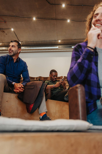 Багатокультурні бізнесмени розважаються і посміхаються в кінці робочого часу в офісі - Фото, зображення