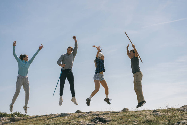 Jóvenes excursionistas celebrando con éxito llegar a la cima de la montaña - Foto, imagen