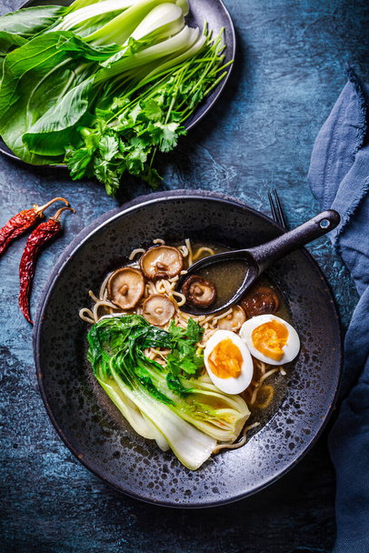 Miso ramen Asijské nudle polévka s shiitake, vejce a pak choi zelí na tmavém pozadí - Fotografie, Obrázek