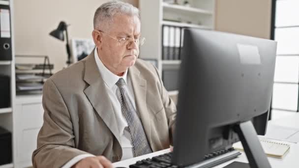 Ofiste çalışan bilgisayar kullanan, orta yaşlı, kır saçlı bir iş adamı. - Video, Çekim