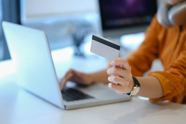 Vyberte si zaměřený na ženskou ruku držící kreditní kartu a pomocí notebooku. Elektronický obchod, bankovní služby a nakupování online. - Fotografie, Obrázek