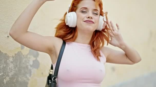 Молода руда жінка слухає музику і танцює на вулиці
 - Кадри, відео