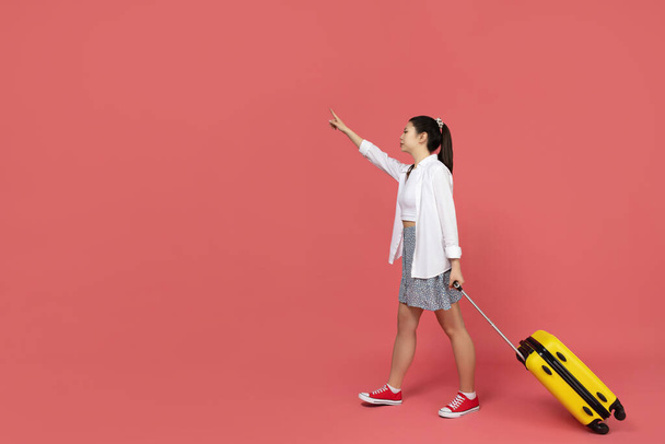 Een Aziatisch meisje gaat op reis, met een gele koffer - Foto, afbeelding