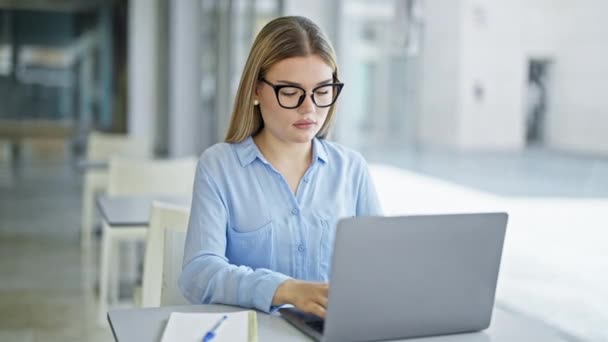 Joven mujer rubia trabajadora de negocios utilizando el ordenador portátil que se extiende relajante en la oficina - Metraje, vídeo