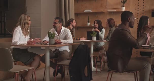 Változatos üzletemberek csoport dolgozik, miközben élvezi a kávézó társalgó az irodában, kamera teherautó mozgás - Felvétel, videó