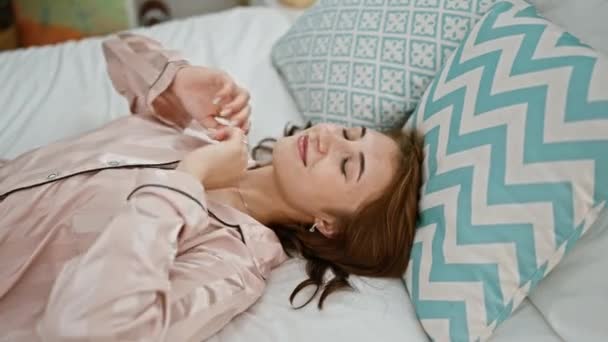 Giovane donna sorridente fiducioso rilassato con le mani sulla testa in camera da letto - Filmati, video