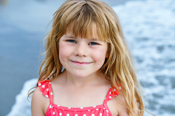 Portret Happy Child, Dziewczynka z przedszkola w stroju kąpielowym biegająca i skacząca w falach podczas wakacji na egzotycznej plaży tropikalnej. Rodzinna podróż na wybrzeżu oceanu - Zdjęcie, obraz
