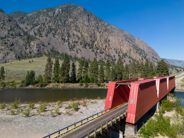 The Ashnola bridge across Similkameen River, was completed in 1907 and rebuilt in 1926 with its Howe trusses sheathed in wood panelling and cross-bracing exposed overhead. It is found in Keremeos, British Columbia, Canada. - Photo, Image