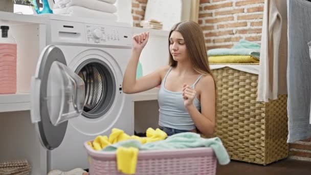 Joven hermosa chica lavando ropa bailando en la lavandería - Imágenes, Vídeo