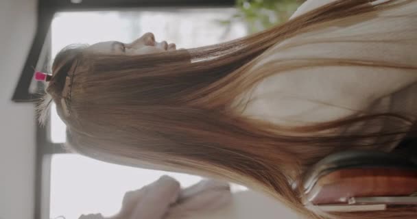 Het toevoegen van hair extensions in dezelfde kleur als origineel haar, professionele kapsalon, verticale video - Video