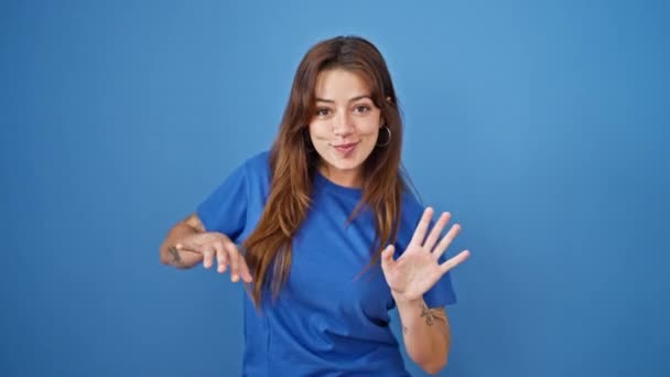 Young beautiful hispanic woman smiling confident dancing over isolated blue background - Footage, Video