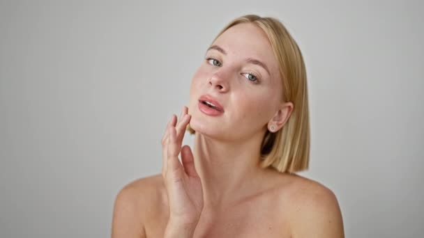 Jeune femme blonde touchant le visage posant sur fond blanc isolé - Séquence, vidéo