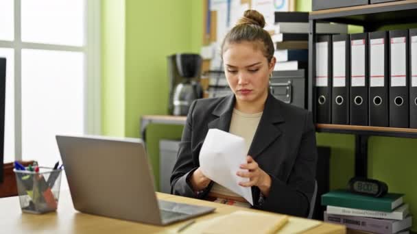 Joven hermosa mujer hispana trabajadora de negocios leyendo carta con expresión preocupada en la oficina - Metraje, vídeo