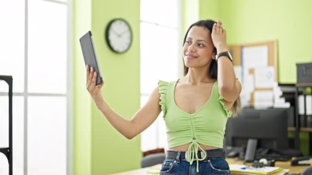 Jovem bela mulher hispânica empresária fazer selfie pelo touchpad no escritório - Filmagem, Vídeo