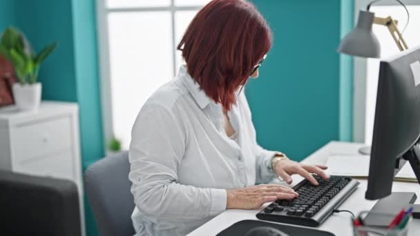 Kobieta w średnim wieku pracownik biznesu cierpiący na bóle pleców pracujących w biurze - Materiał filmowy, wideo