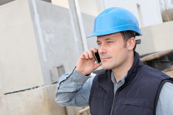 Supervisor talking on the phone on construction site - Фото, изображение