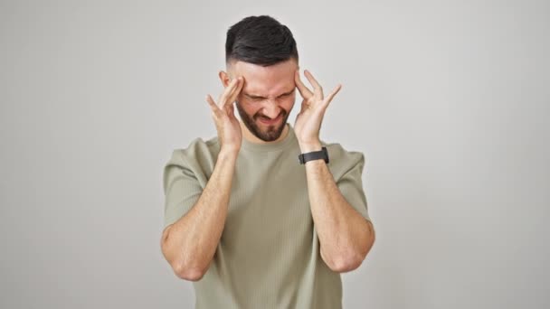 Hombre hispano joven que sufre de dolor de cabeza sobre fondo blanco aislado - Metraje, vídeo