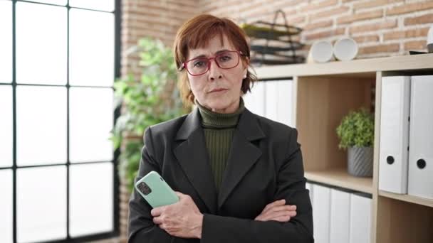 Érett spanyol nő üzleti dolgozó komoly arc gazdaság okostelefon az irodában - Felvétel, videó