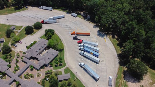 Eine Reihe von Sattelschleppern parkt auf dem Highway Interstate 10 Rastplatz, große Container-Stellplätze für Anhänger halten in der Nähe von Greenwood, Louisiana Willkommenszentrum im Sommer sonnigen wolkenblauen Himmel. Amerika - Foto, Bild