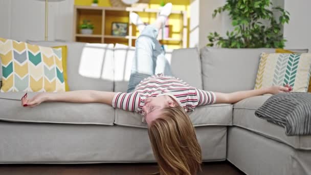 Fiatal szőke nő mosolygós magabiztos feküdt kanapén otthon - Felvétel, videó
