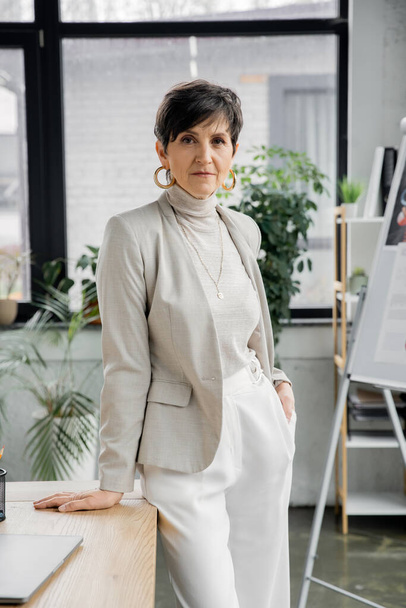ervaren middelbare leeftijd zakenvrouw met hand in zak in modern kantoor, headshot, portret - Foto, afbeelding