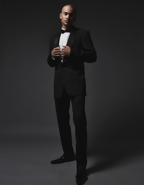 Studio fashion portrait of a handsome young African American businessman wearing a black suit and tie - Photo, Image