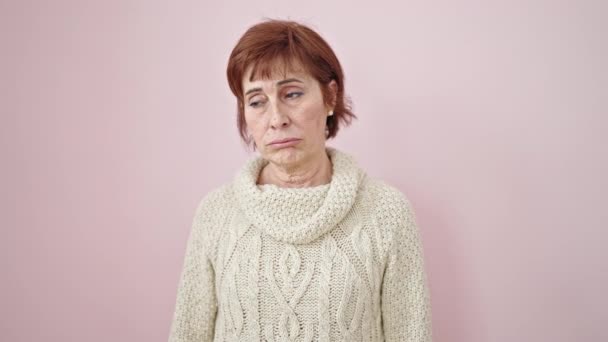 maduro hispânico mulher de pé com chato expressão sobre isolado rosa fundo - Filmagem, Vídeo