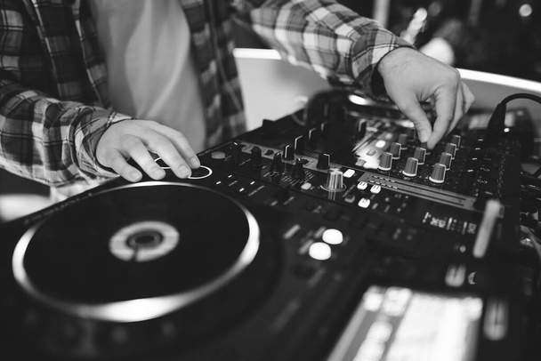 a DJ plays music on a controller at a party - Foto, imagen