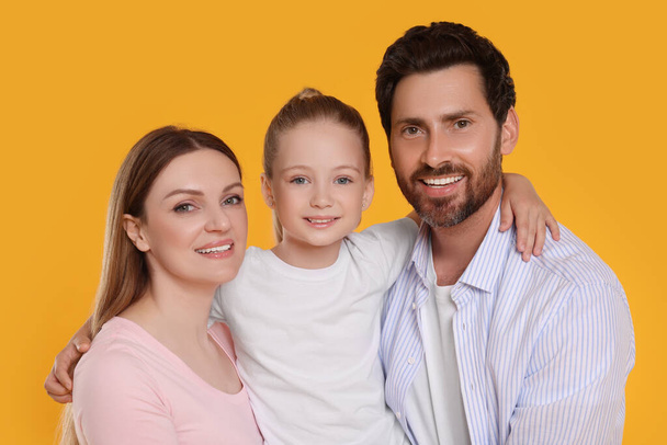 Portrait of happy family on orange background - Foto, Imagen
