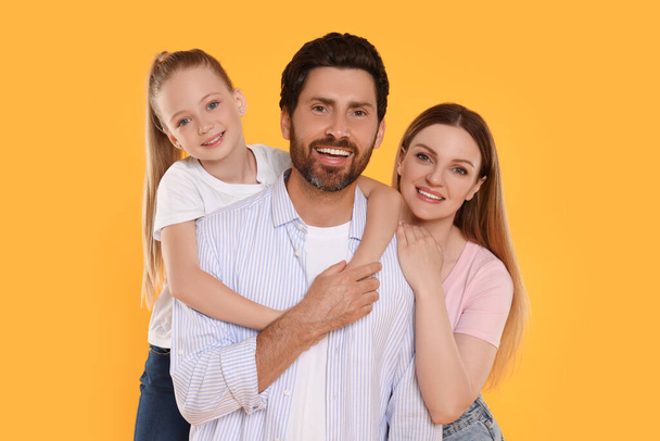 Portrait of happy family on orange background - Fotografie, Obrázek
