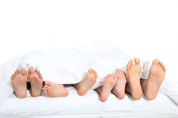 Gros plan des pieds de la famille au lit
 - Photo, image