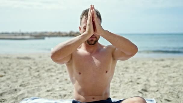 Young man tourist training yoga exercise at the beach - Footage, Video