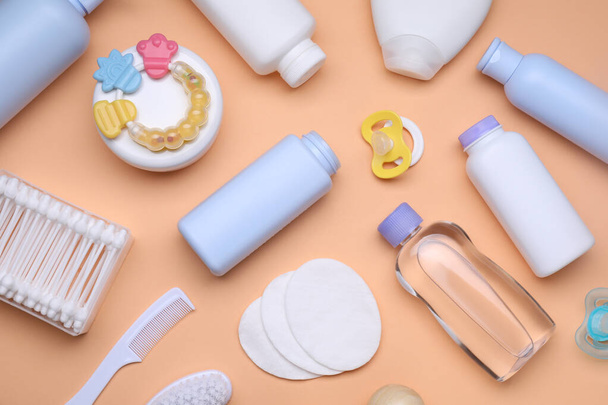 Flat lay composition with baby care products and accessories on pale orange background - Photo, Image