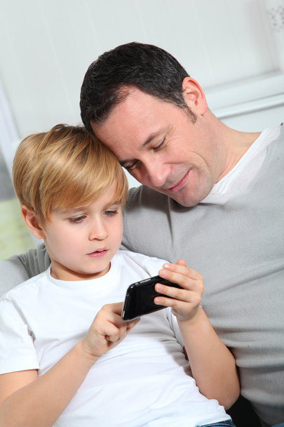 Father and son playing video game at home - Foto, afbeelding