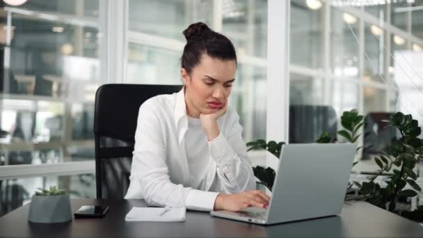 Mujer joven hispana aburrida y desmotivada cansada de trabajar con un portátil - Imágenes, Vídeo