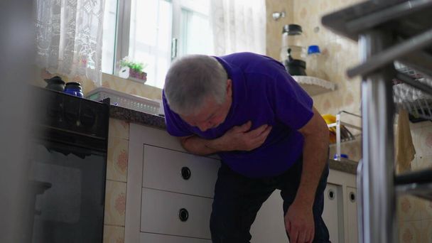 Starszy mężczyzna cierpiący na palpitacje klatki piersiowej, dramatyczny atak serca w domu Scena spada na ziemię, starsza osoba omdlewa na podłodze w kuchni - Zdjęcie, obraz