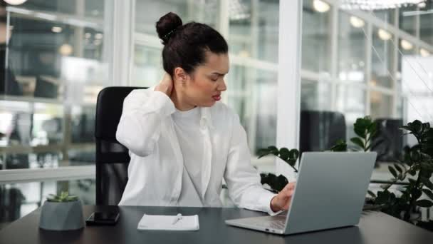 Tired Latin spanish businesswoman is experiencing neck pain working in office - Footage, Video
