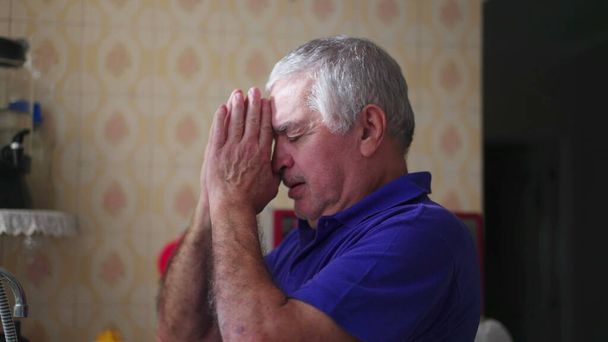 Людина похилого віку в сподіваній молитві, шукає сорому через віру вдома. Відступник старшого в медитативній молитві, прийняття віри у важкі часи - Фото, зображення