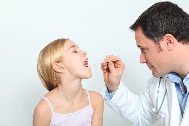 Pediatrician checking little girl throat - Foto, Imagen