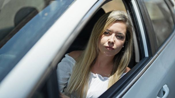 Giovane donna bionda guida auto in strada - Foto, immagini
