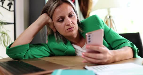 Businesswoman sad depressed holding smartphone and waiting for call and sms. Negative emotions anxiety and reading news online - Séquence, vidéo