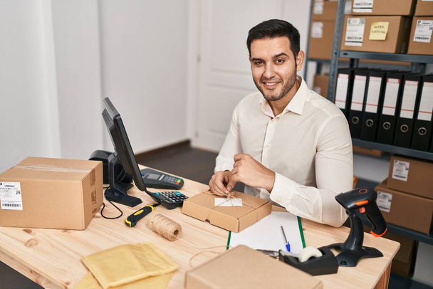 Молодий іспаномовний працівник електронної комерції підготував пакет в офісі
 - Фото, зображення