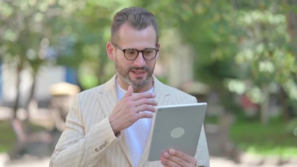 Hombre de mediana edad celebrando el éxito en la tableta al aire libre - Metraje, vídeo