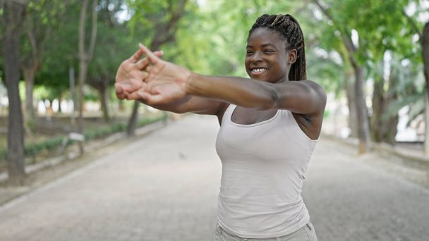 Afrikai amerikai nő mosolyog magabiztos kinyújtott karok a parkban - Fotó, kép
