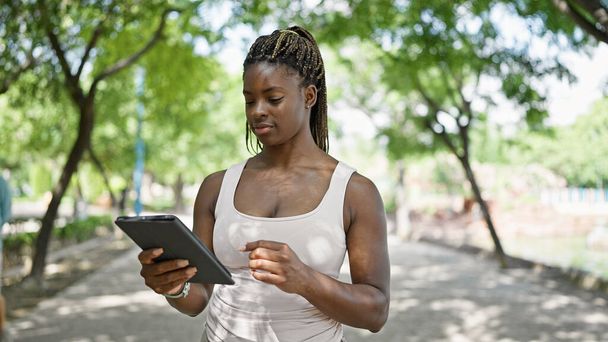 African american woman using touchpad at park - Foto, Imagen