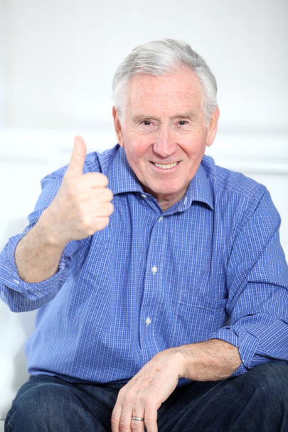 Portrait of smiling elderly man with thumb up - Photo, image