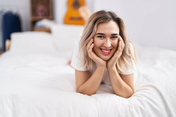 Young woman smiling confident lying on bed at bedroom - Photo, Image